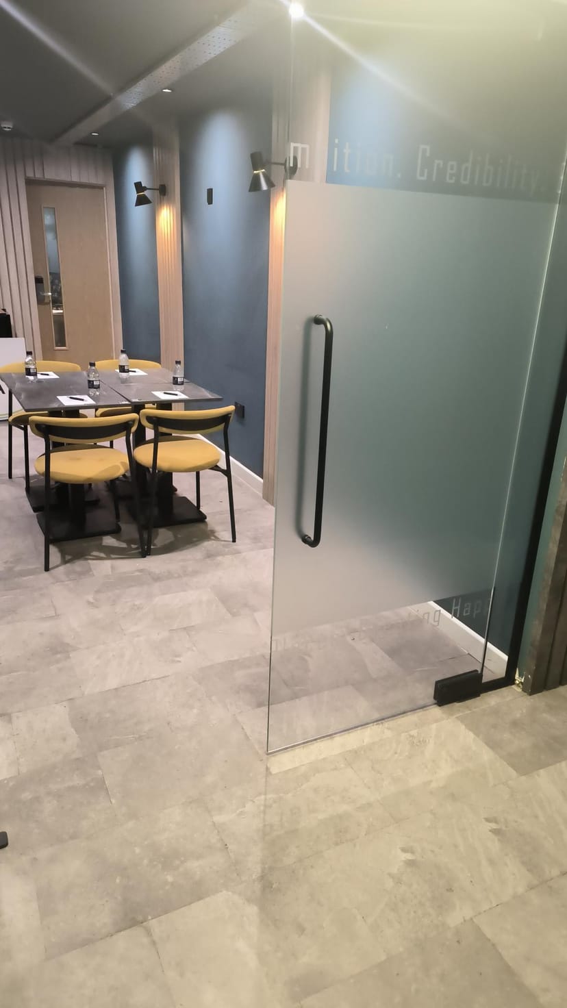 Modern meeting room with glass door and yellow chairs at The Plaza Hotel, Chorley.