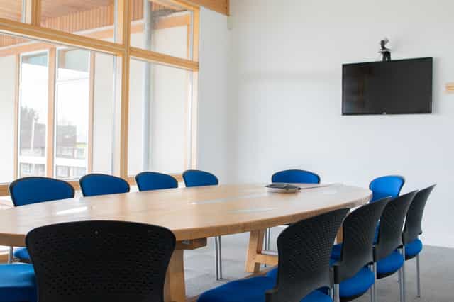 Modern conference room at Knowle West Media Centre with a large wooden table for meetings.