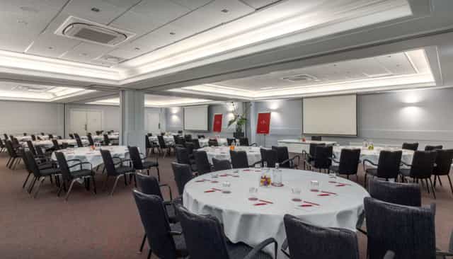 Elegant event space with round tables for corporate meetings and banquets.