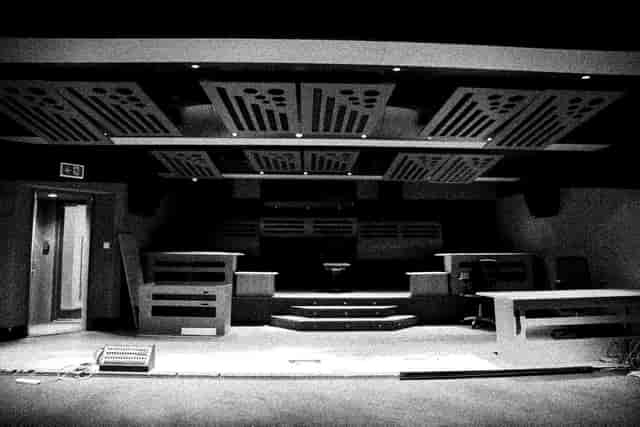 Versatile event space with stage and acoustic panels for presentations and performances.