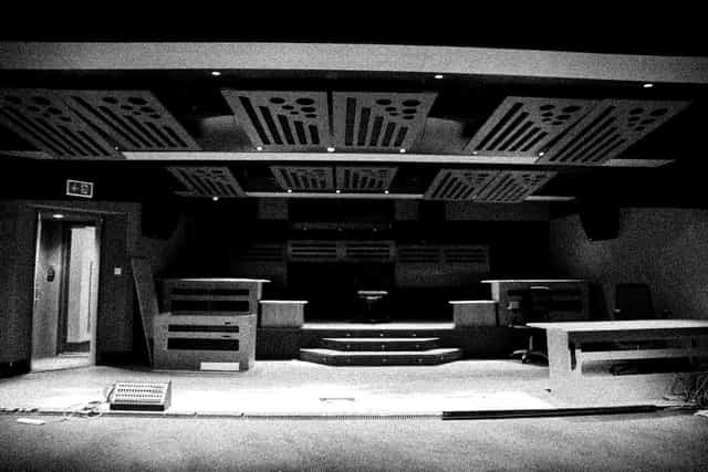 Versatile event space with stage and acoustic panels for presentations and performances.