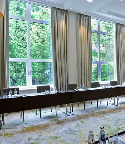 Kemp in Waldorf Astoria meeting room with natural light, ideal for corporate events.