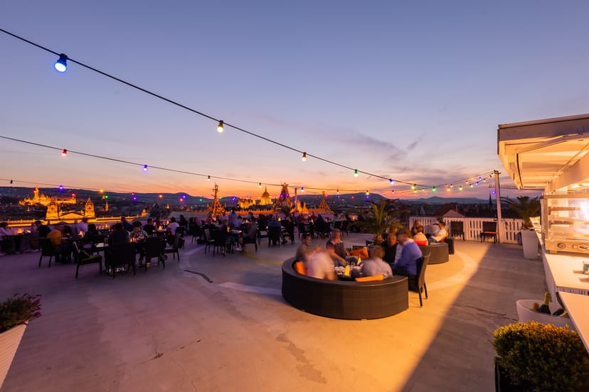 Rooftop venue at sunset with string lights, ideal for events and gatherings.