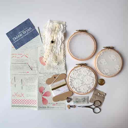 Craft kits for textile arts workshop with embroidery hoops and lace samples.