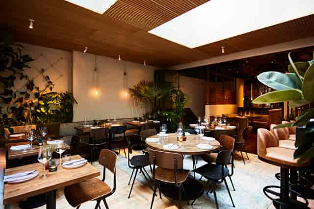 Stylish restaurant interior with round tables, ideal for corporate events and networking dinners.