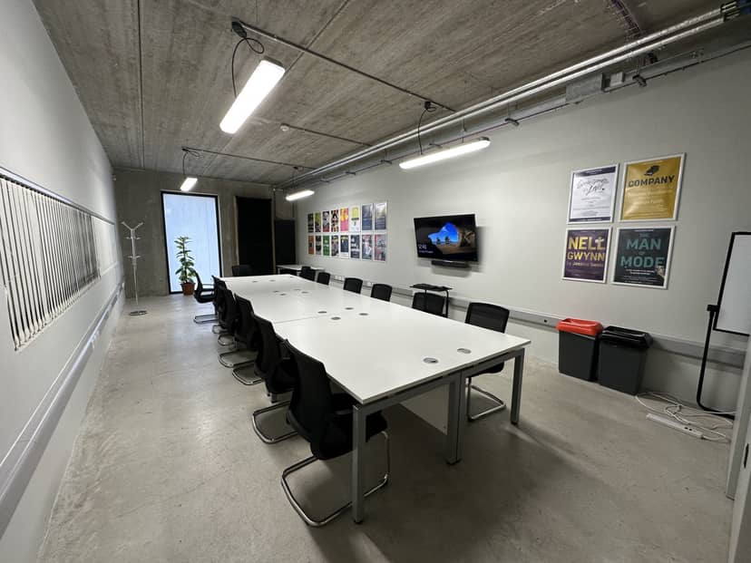 Modern conference room with white table, ideal for collaborative meetings and events.