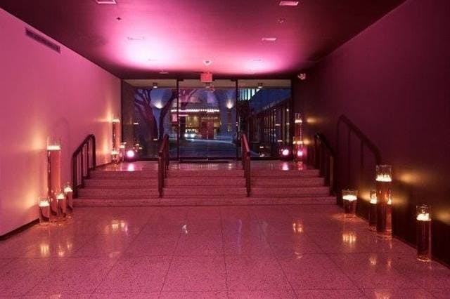 Stylish entrance with pink lighting and elegant staircase for fashion events.