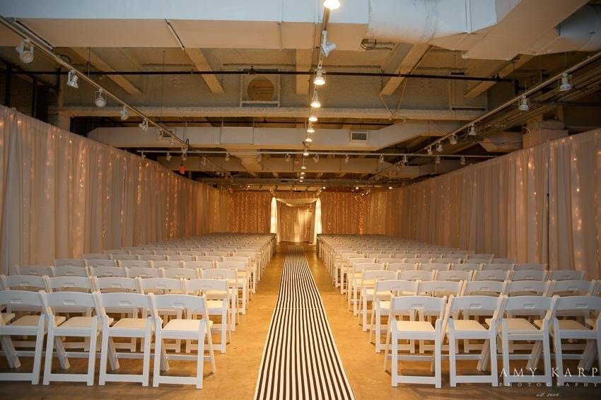 Elegant wedding venue with white chairs and soft lighting for formal gatherings.