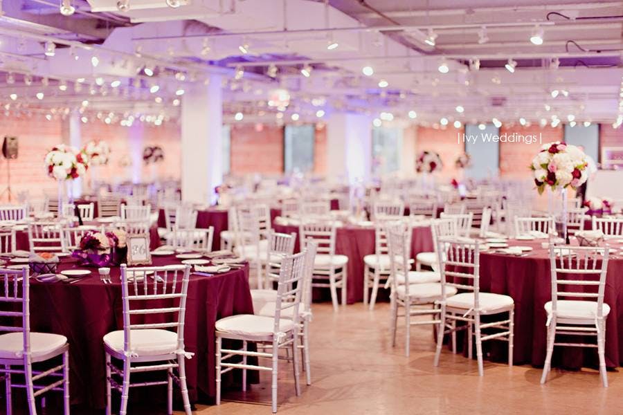 Elegant event space with burgundy tables, ideal for weddings and upscale gatherings.