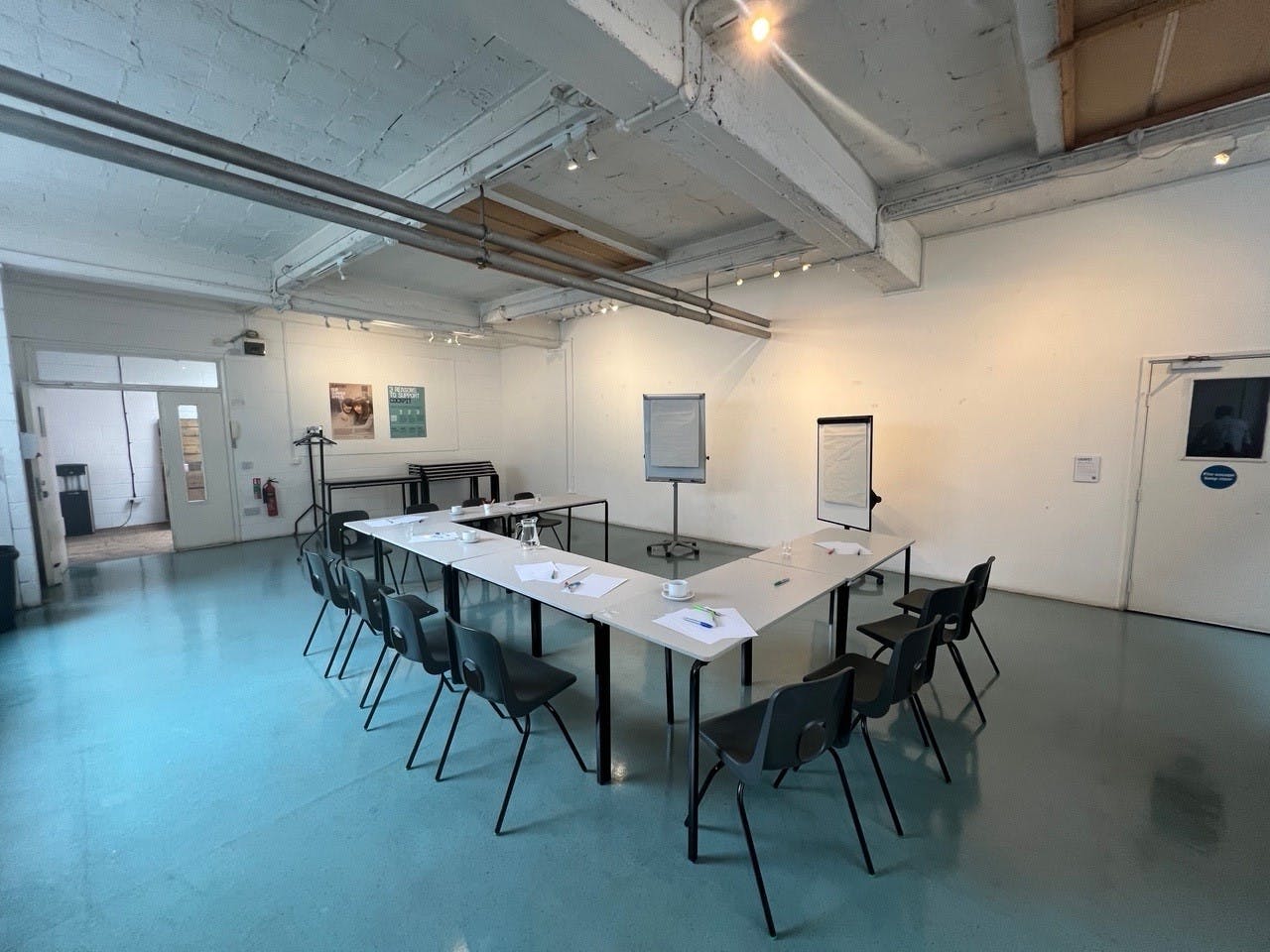 Well-lit meeting room with long table, ideal for workshops and strategy sessions.