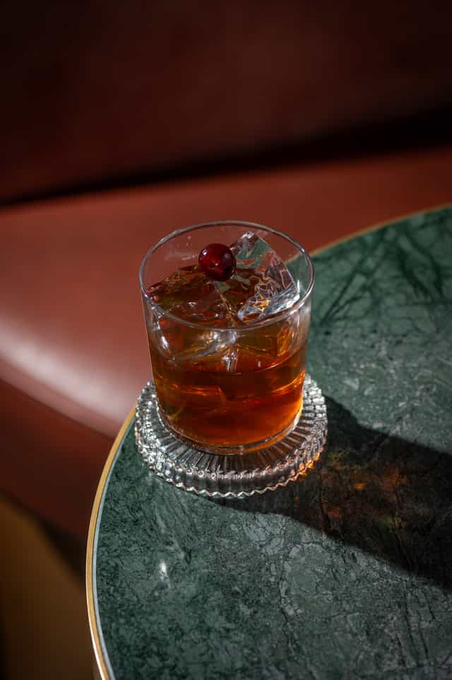 Elegant cocktail with cherry garnish at The Bar, Clays Birmingham for networking events.