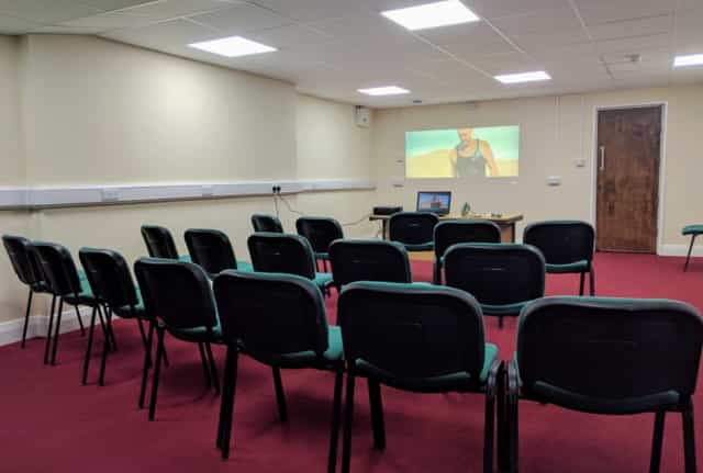 Lozells Community Centre meeting room with chairs and projection screen for presentations.