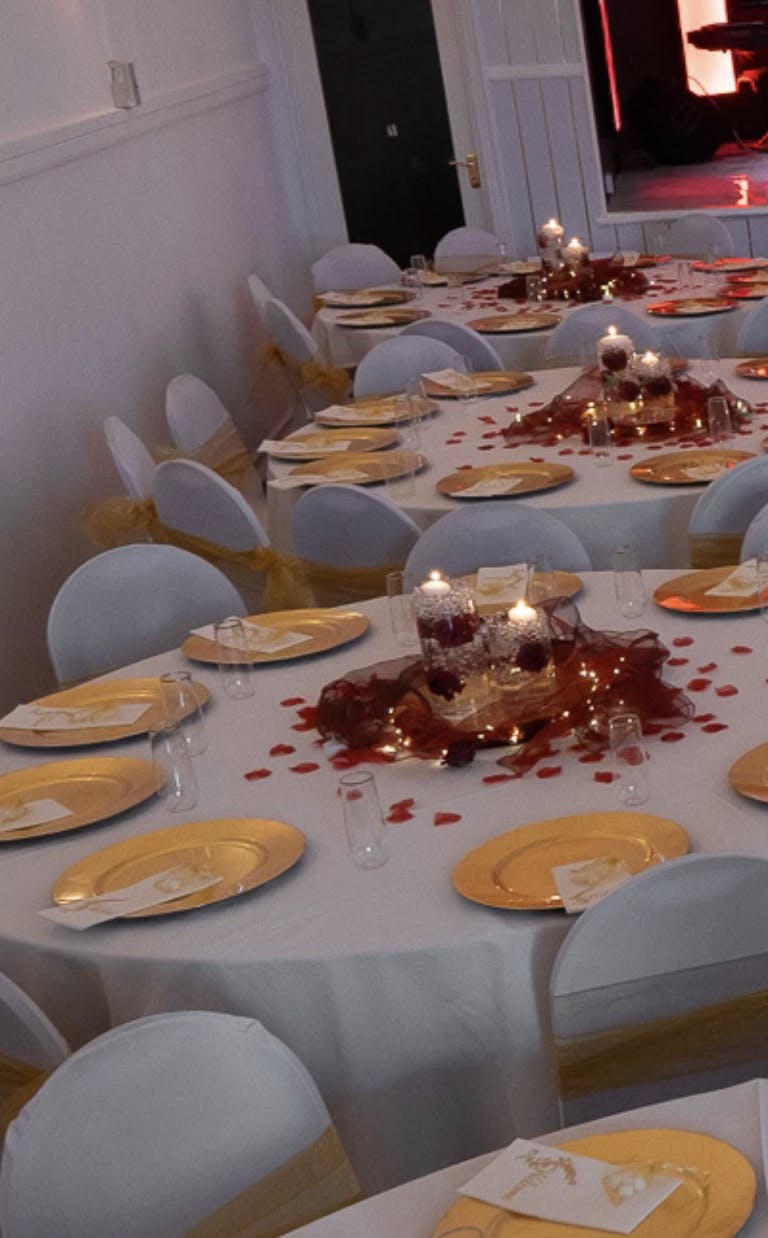 Elegant banquet table with gold chargers in GENESIS HALL for weddings and formal events.