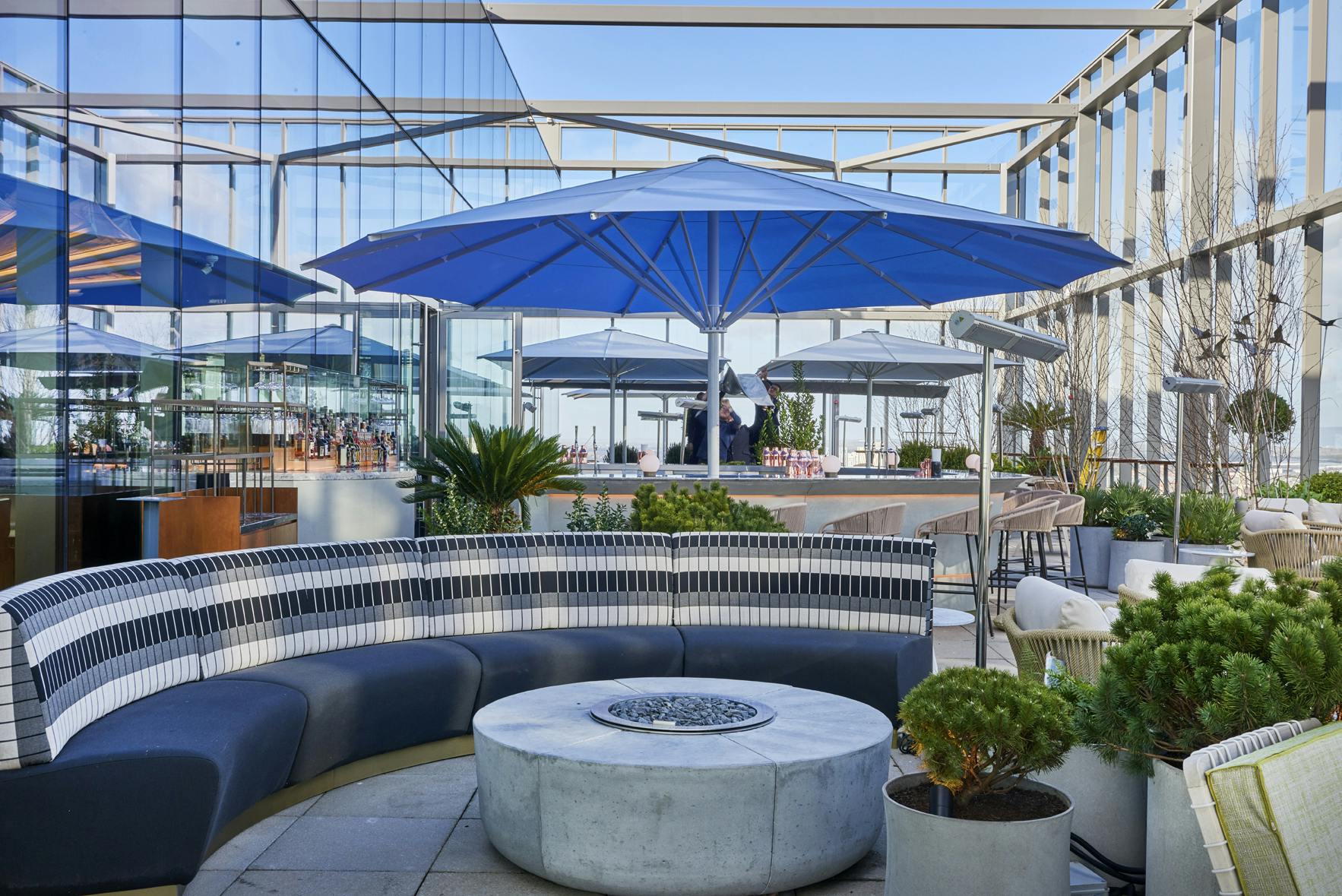 Stylish rooftop venue with blue umbrellas, perfect for events and gatherings.