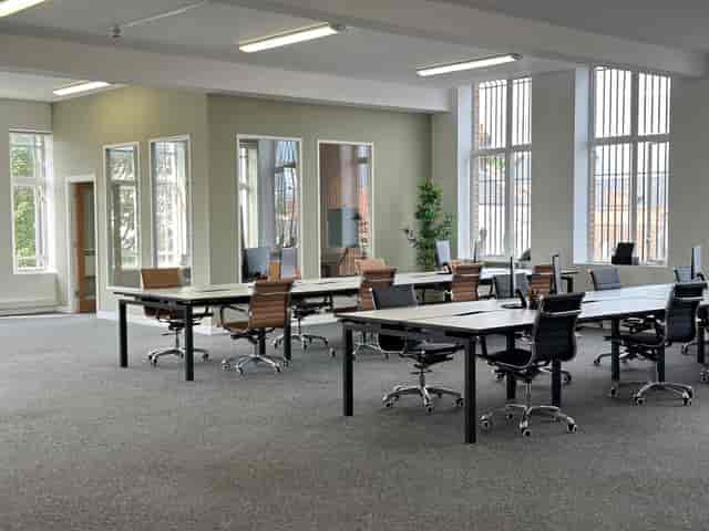 Spacious meeting room with modern desks, ideal for workshops and brainstorming sessions.