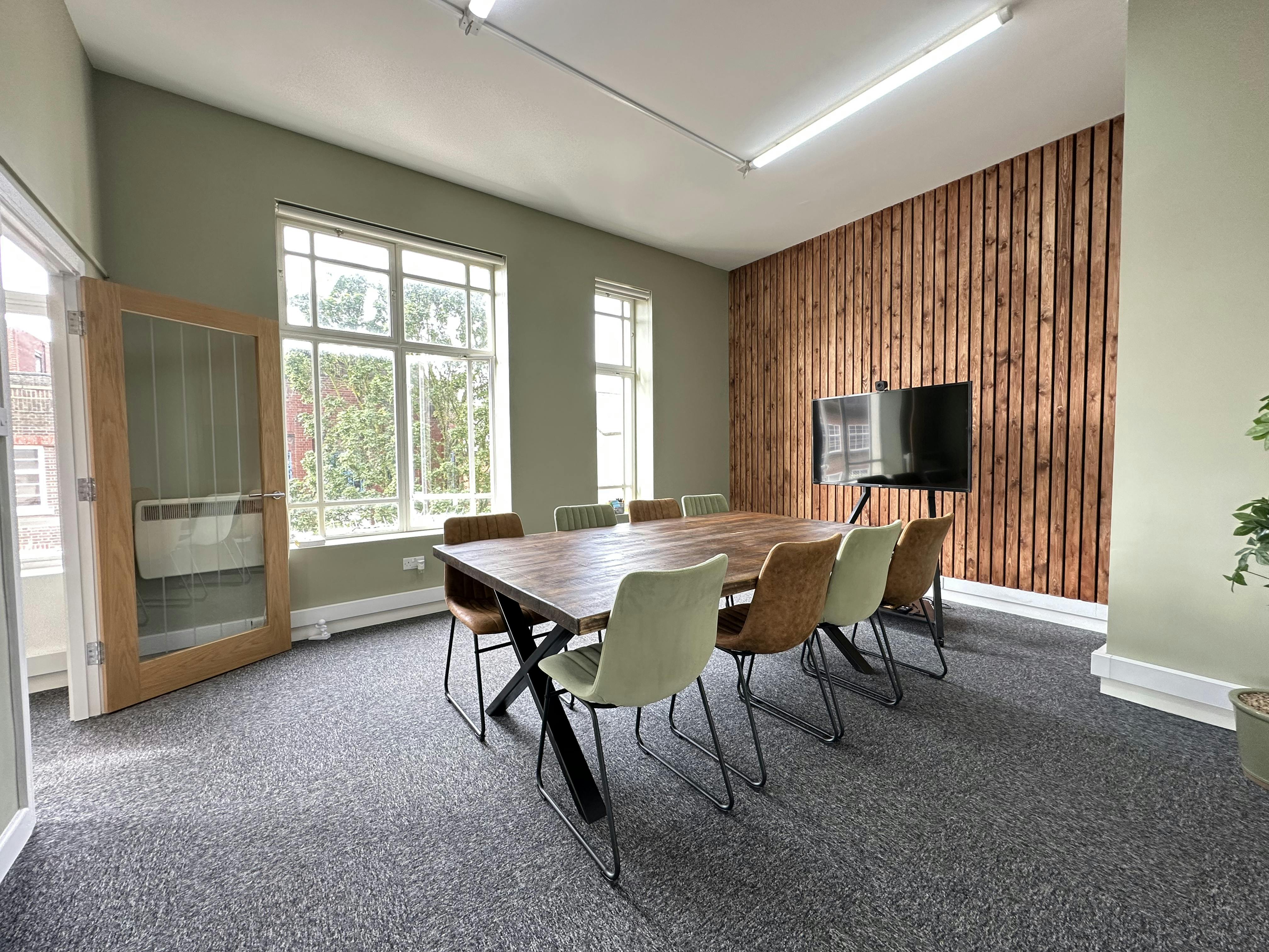 Modern meeting room with wooden table, ideal for collaborative business events.