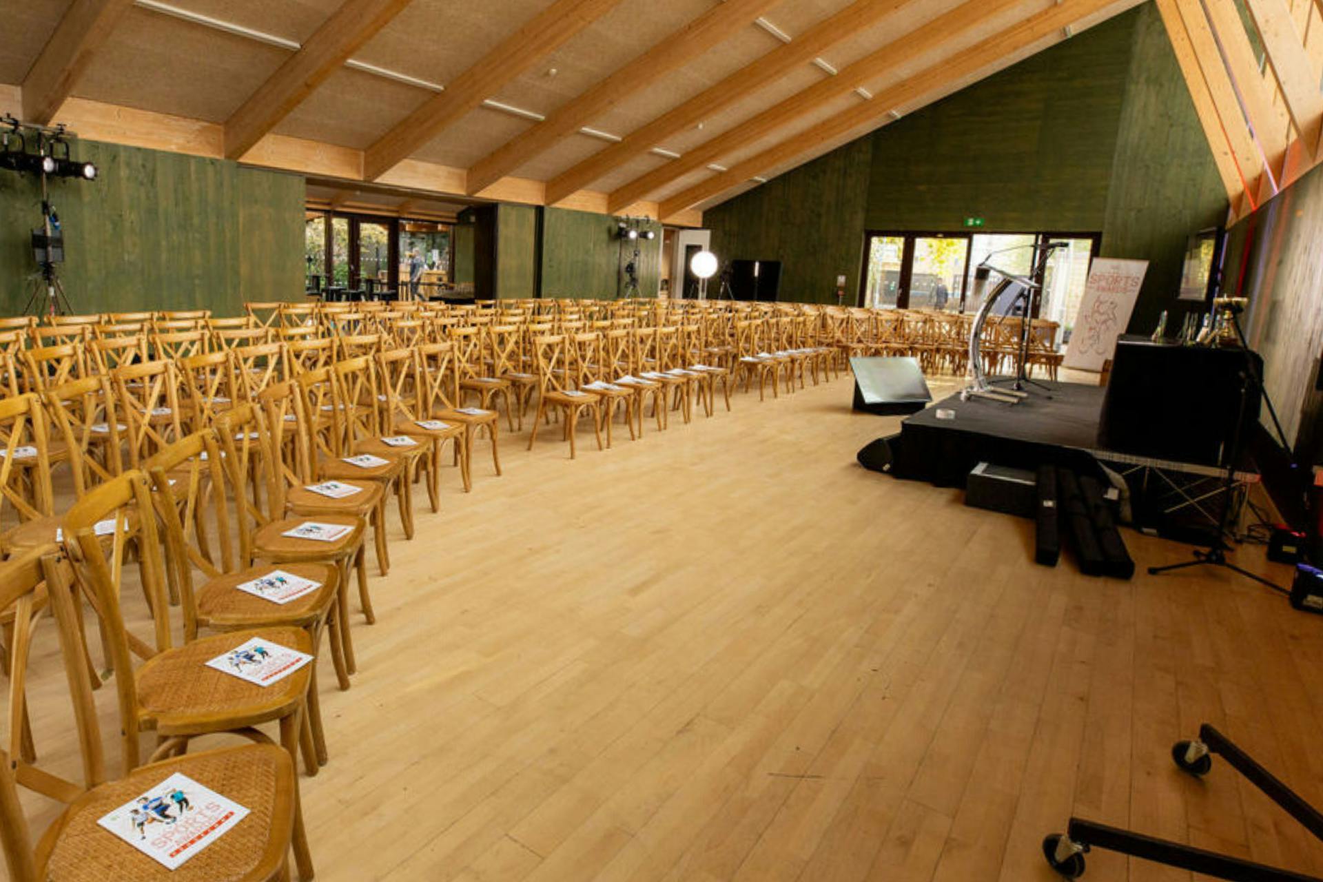 Spacious Sands End event venue with wooden chairs, ideal for conferences and presentations.