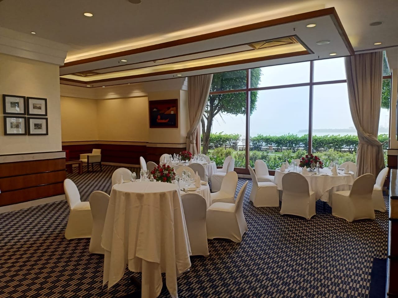Elegant event space at Sunset Lounge, Mumbai with round tables and natural light.
