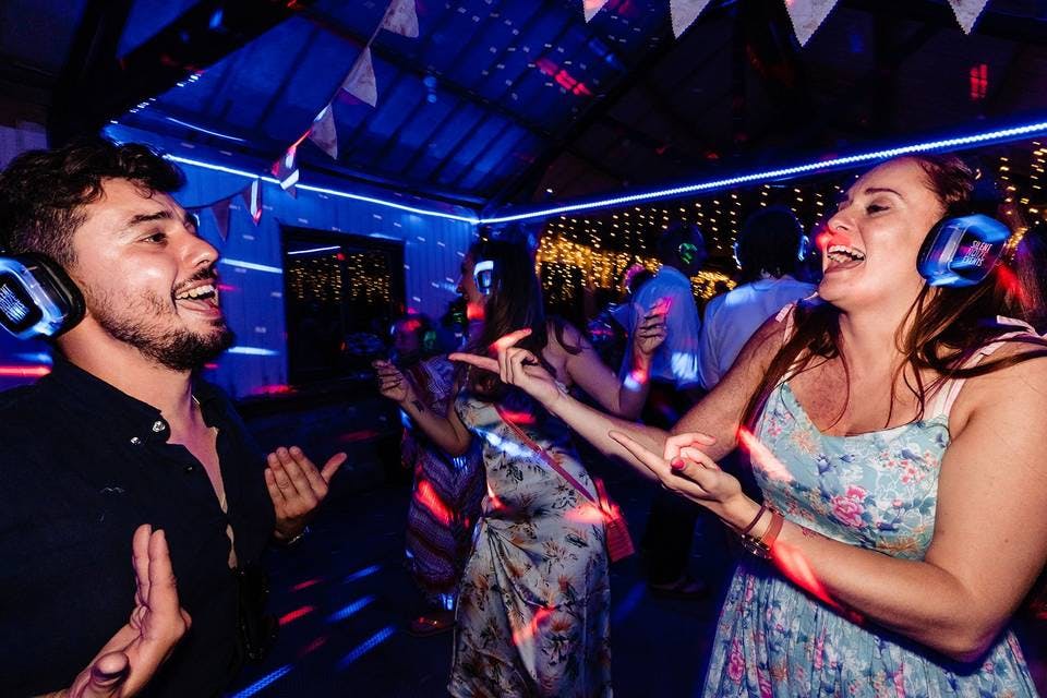 Vibrant DJ booth at Silent Noize silent disco event with colorful lighting.