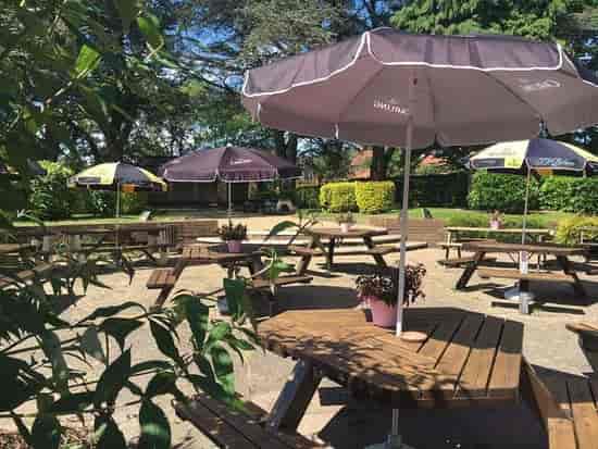 Outdoor event space at The Court Oak Harborne with picnic tables and umbrellas.