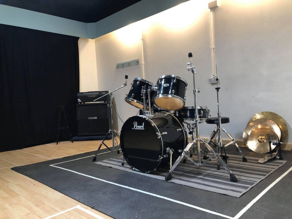 Recording studio with drum kit, ideal for live music events and creative workshops.