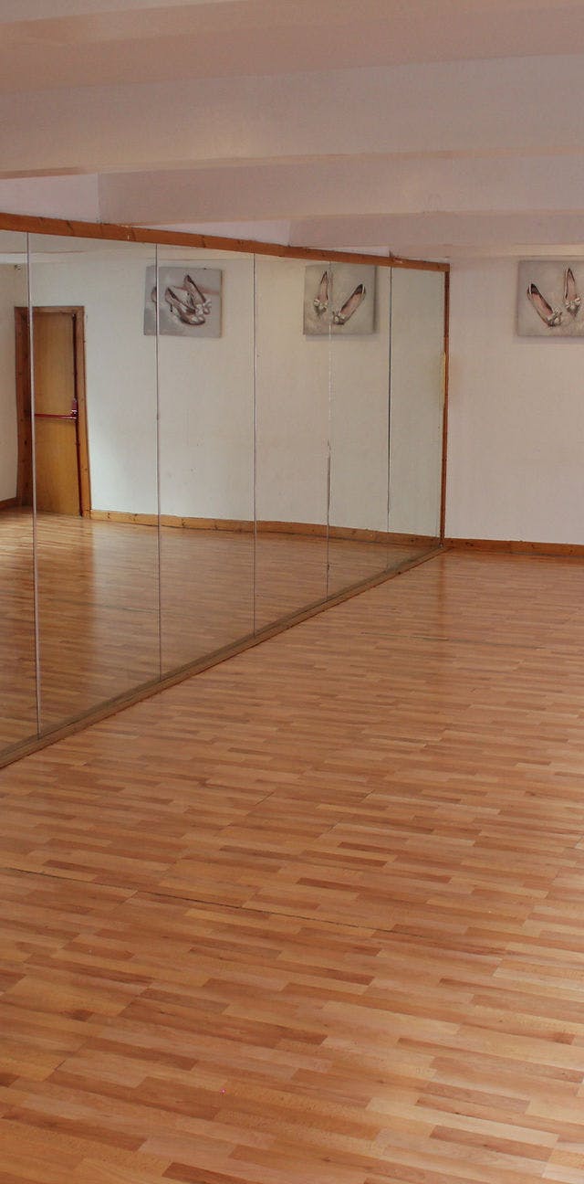 Spacious dance room with mirrored walls, perfect for workshops and fitness classes.