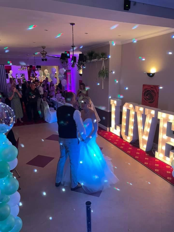 Wedding reception at The Old Rose and Crown Hotel with couple's first dance under vibrant lights. - Banner