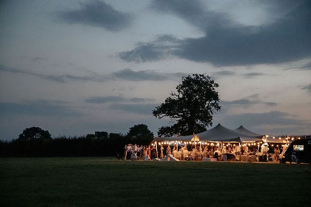 Stretch tent with string lights at Wildflower Events Field for elegant outdoor weddings.