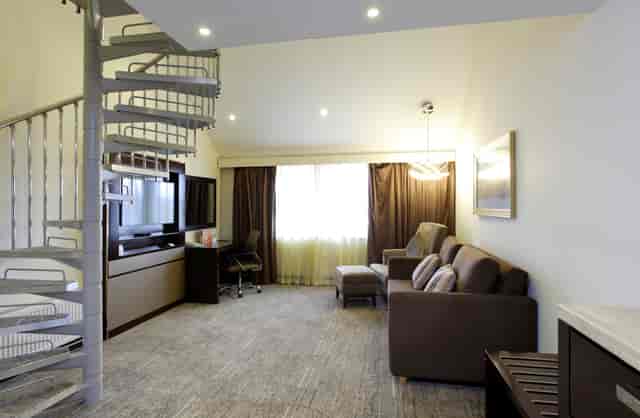 Modern meeting room with cozy seating and spiral staircase at Ramada Solihull Birmingham.