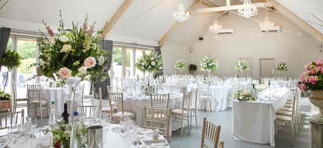 Elegant wedding ceremony room with floral centerpieces at Blackwell Grange.