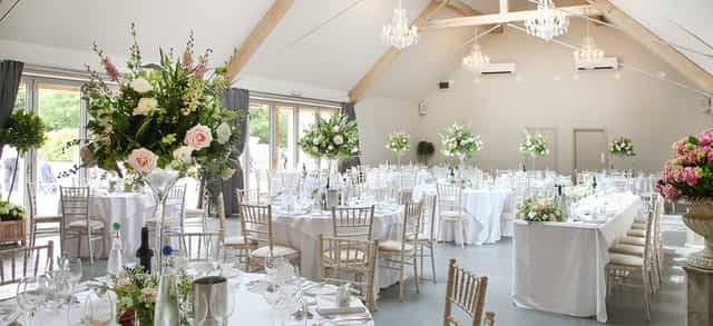 Elegant wedding ceremony room with floral centerpieces at Blackwell Grange.