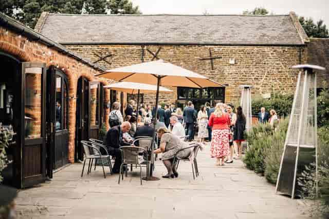 Courtyard Barn at Dodmoor House: vibrant outdoor event space with umbrellas for gatherings.