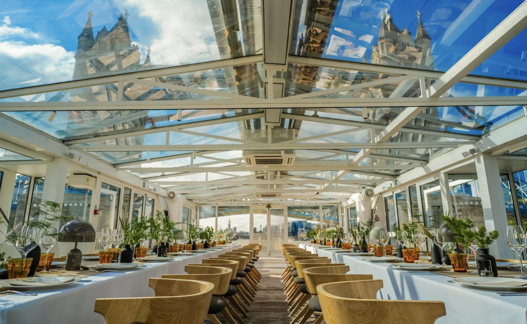 Elegant dining table under glass roof at Driftwoods, perfect for upscale events.