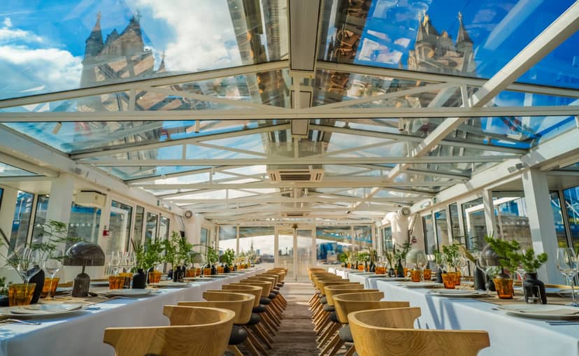 Elegant dining table under glass roof at Driftwoods, perfect for upscale events.