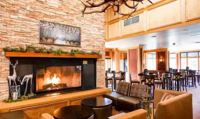 Cozy lounge with stone fireplace at Keystone Lodge for networking events and meetings.