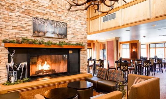 Cozy lounge with stone fireplace at Keystone Lodge for networking events and meetings.