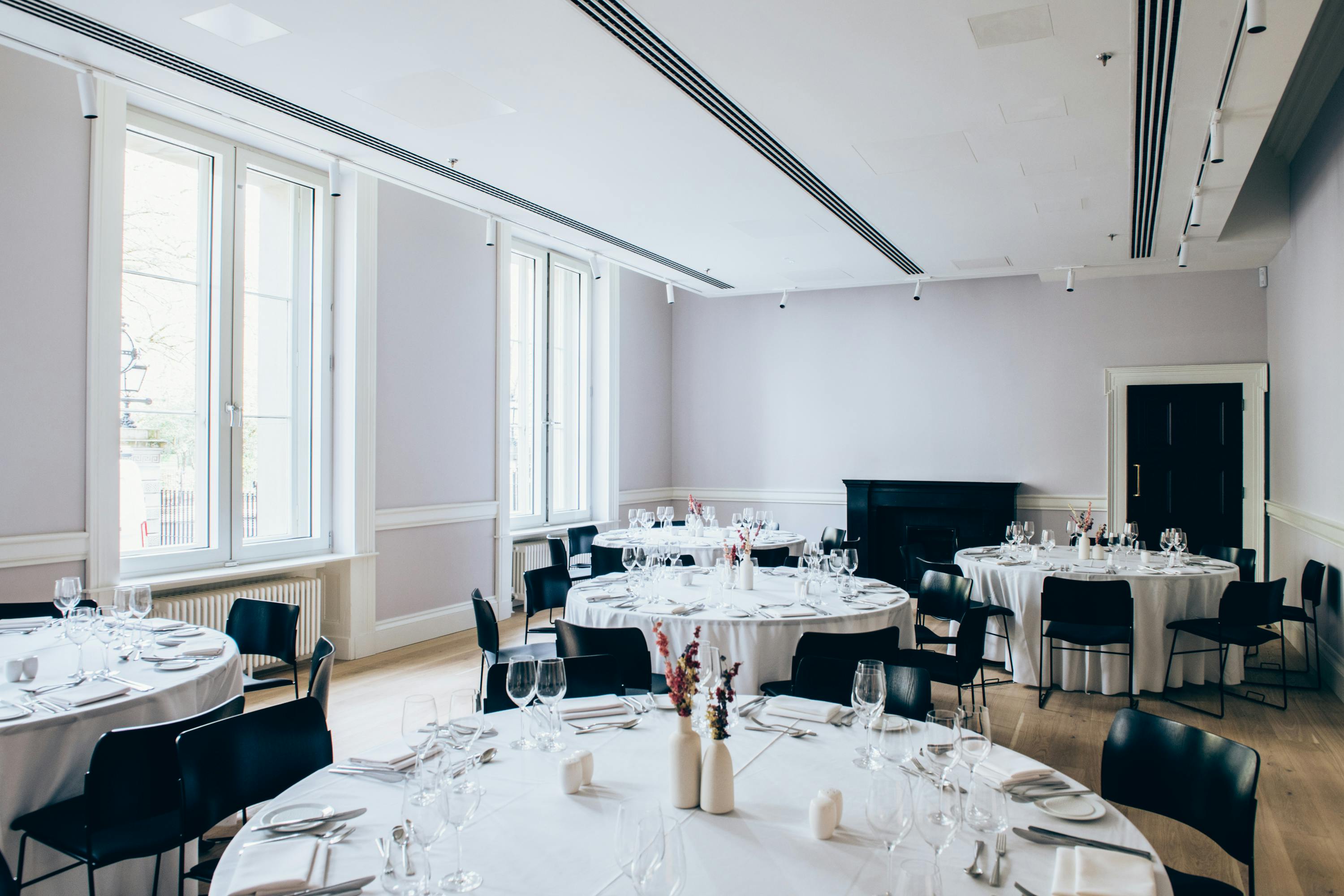 Elegant event space with round tables, perfect for corporate gatherings and weddings.