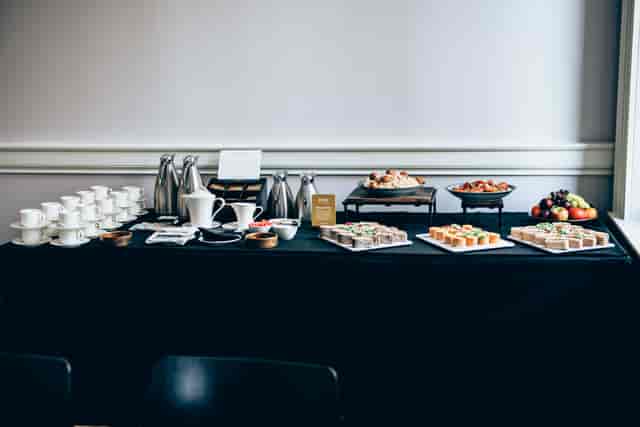 Refreshment station with coffee, tea, and pastries for meetings and events.