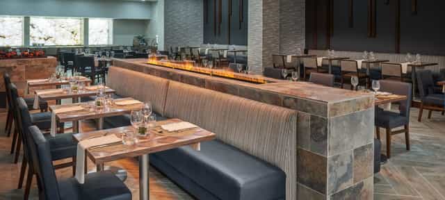 Raphael Ballroom at Hilton Houston: modern dining space with stone bar, ideal for events.