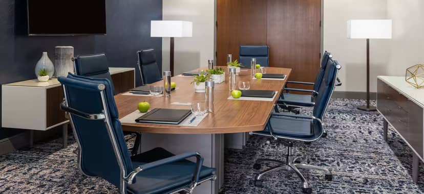 Modern conference room in Hilton Houston with wooden table, ideal for corporate meetings.