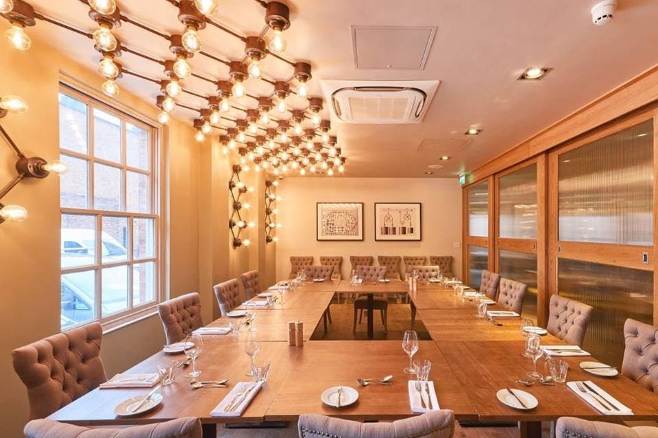 Stylish meeting room with wooden table, ideal for gatherings and upscale dining events.