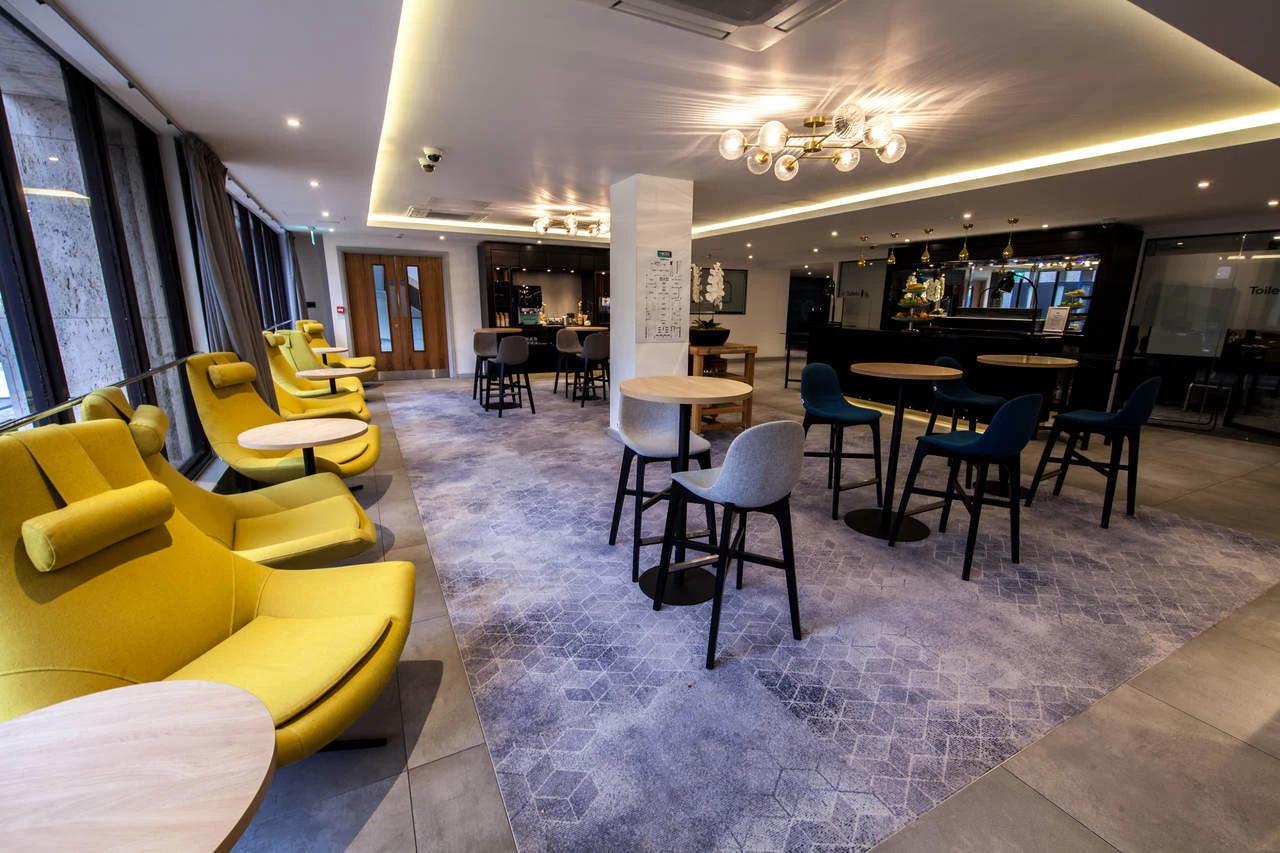 Modern BCEC conference center with bright yellow chairs for networking events. - Banner