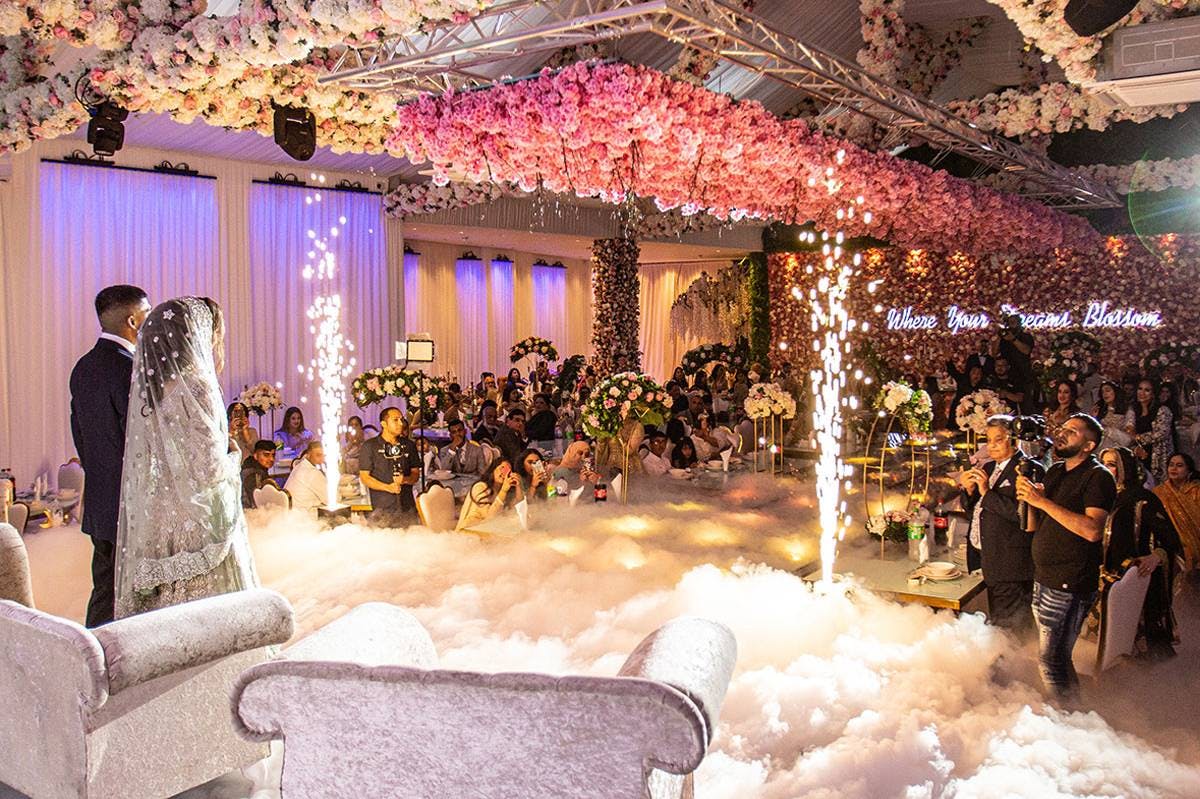 Wedding ceremony in Grand Botanical Suite with floral backdrop and sparklers.