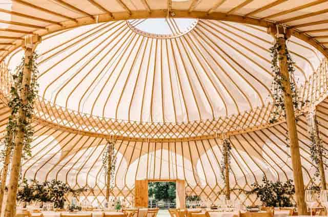 Yurt event space with wooden framework, ideal for weddings and corporate retreats.