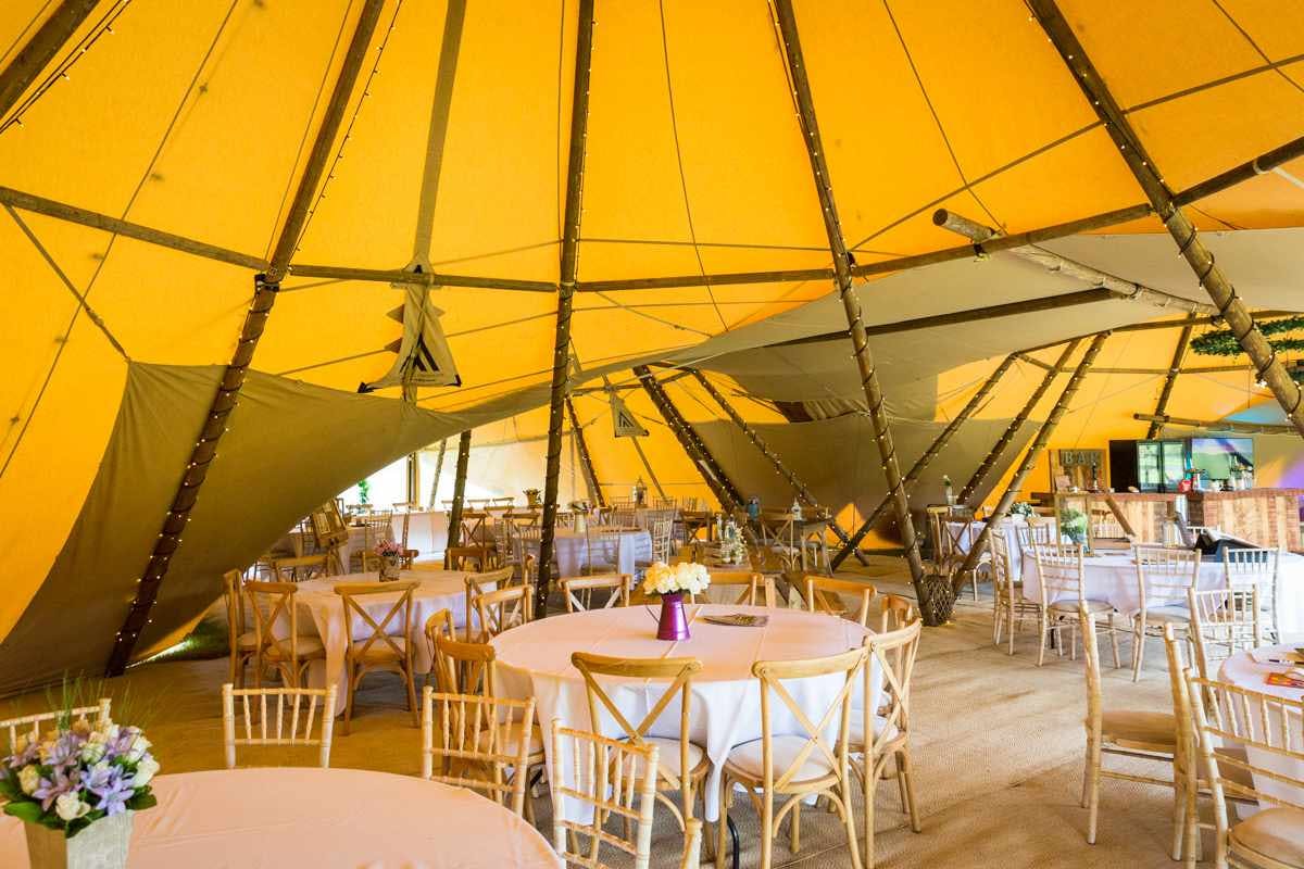 Tipis at Alcott Weddings: warm yellow tent for elegant dining and gatherings.