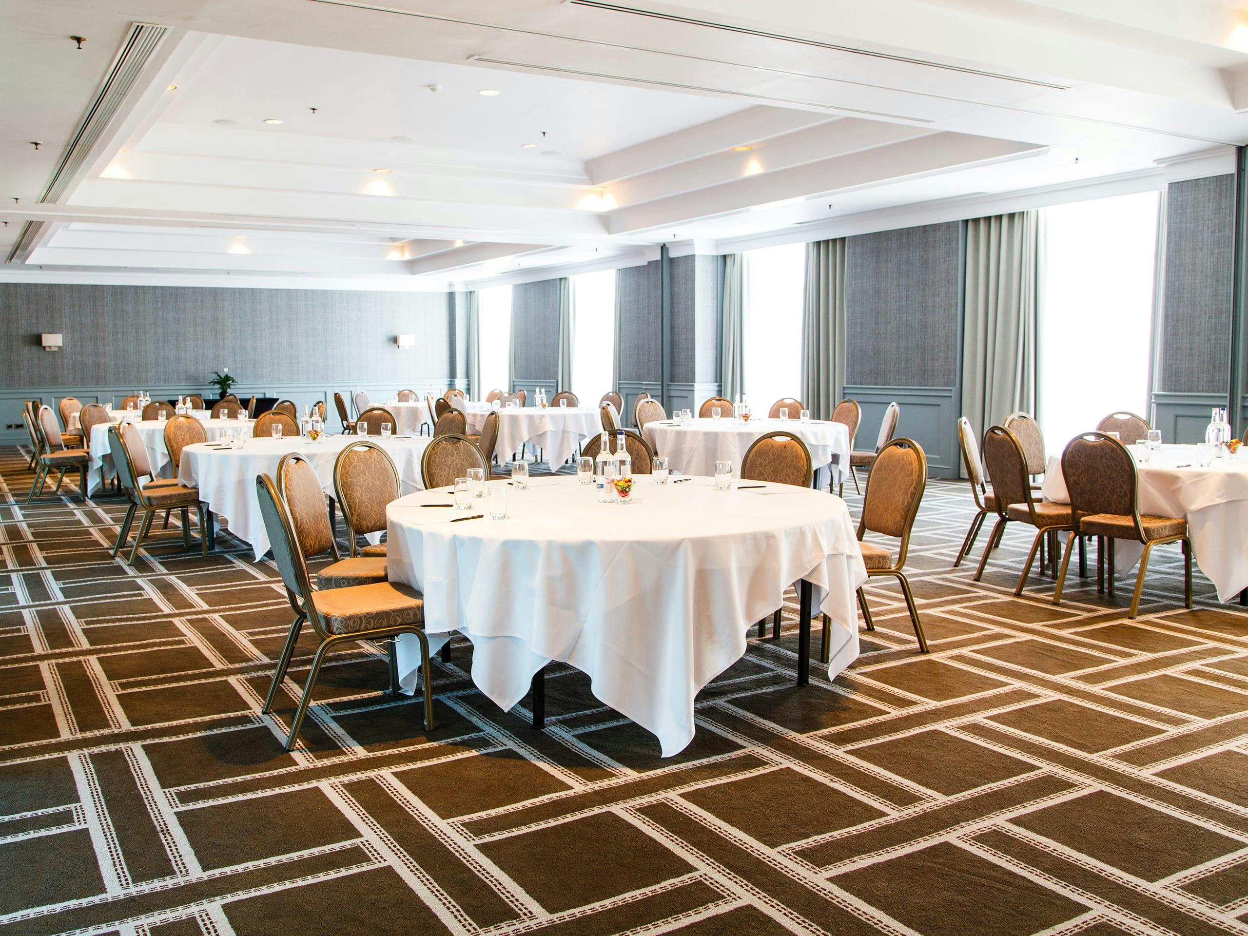 Spacious Regency Banqueting Suite with round tables, ideal for banquets and conferences.