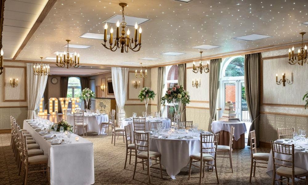 Elegant wedding venue with floral decor and romantic "LOVE" display at Shama's Banqueting.
