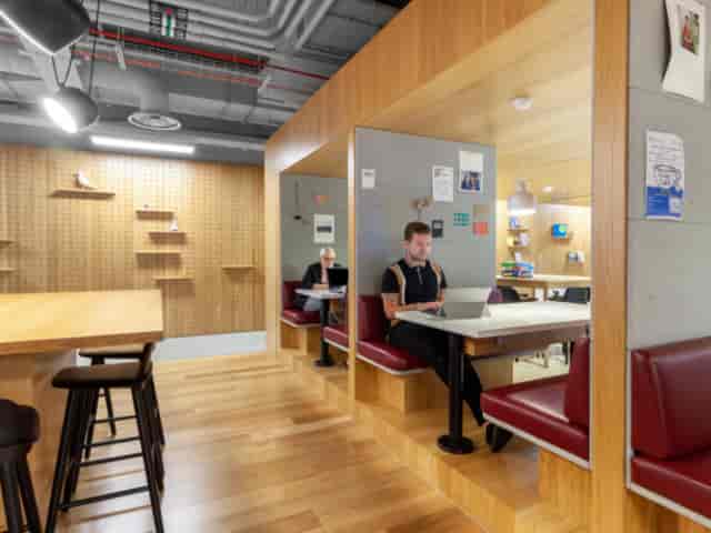 Lewis Building co-working space in Birmingham with warm wood accents for flexible meetings.