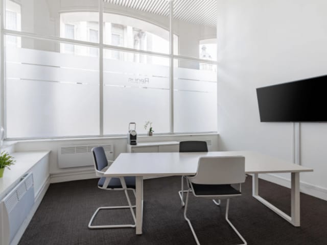 Modern meeting room with large windows for natural light, ideal for conferences and brainstorming.