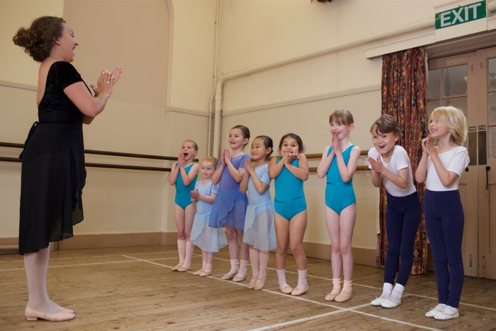 Dance instructor guiding young ballet students at Rutleigh Norris School of Dance.